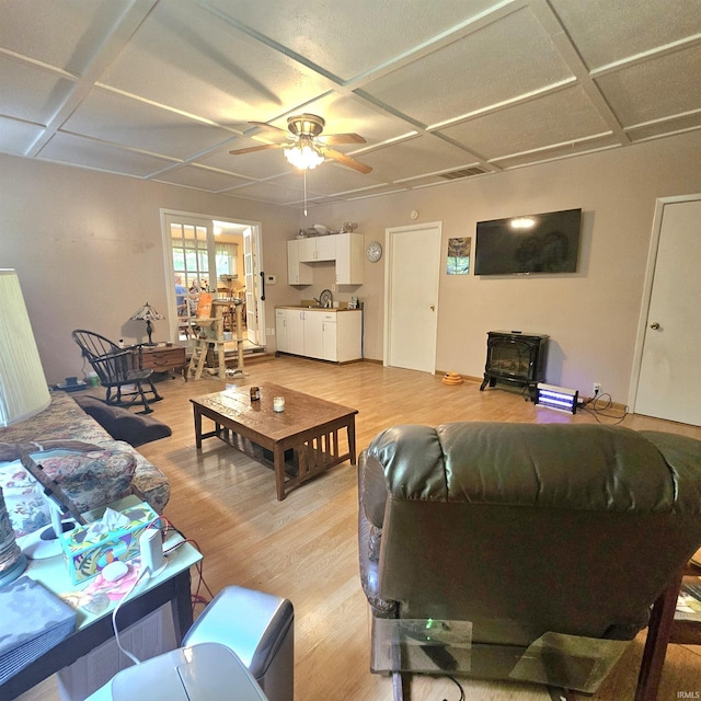 989 S Cataract Rd, Spencer, IN 47460 - living room featuring coffered ceiling, light wood-style floors, a ceiling fan, and a wood stove