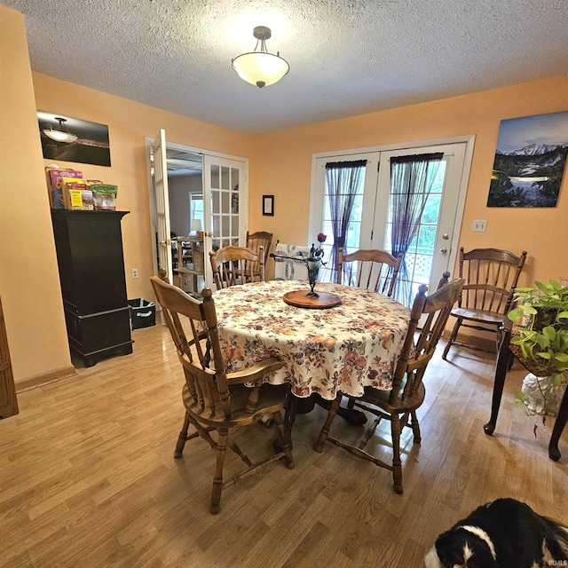 989 S Cataract Rd, Spencer, IN 47460 - dining space with french doors, light wood-type flooring, and a textured ceiling