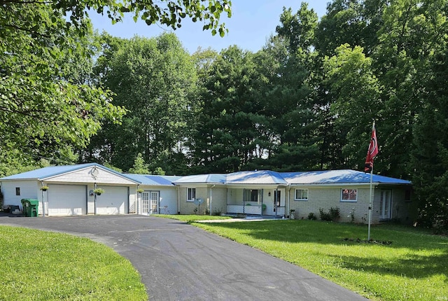 989 S Cataract Rd, Spencer, IN 47460 - single story home featuring a garage, a front lawn, brick siding, a metal roof, and asphalt driveway