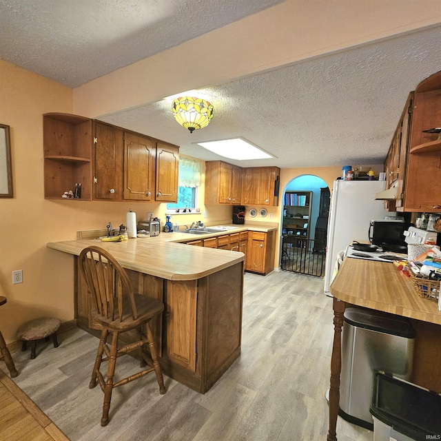 989 S Cataract Rd, Spencer, IN 47460 - kitchen with open shelves, a peninsula, light countertops, brown cabinets, and a textured ceiling