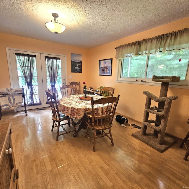 989 S Cataract Rd, Spencer, IN 47460 - dining space with light wood-style flooring, french doors, and a textured ceiling