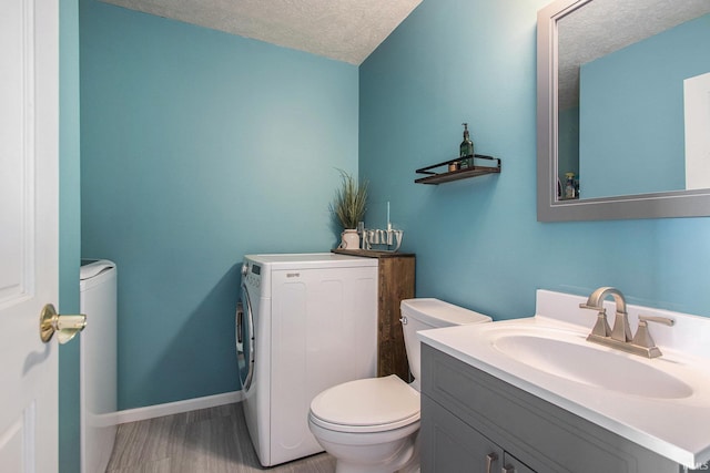 1946 Renfrew Dr, South Bend, IN 46614 - bathroom with a textured ceiling, vanity, wood finished floors, and washing machine and clothes dryer