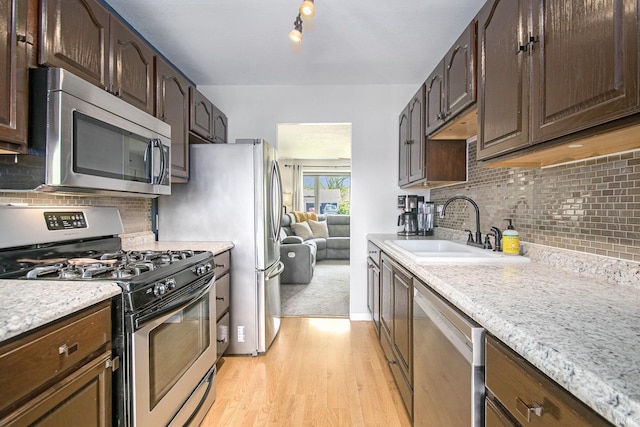 1946 Renfrew Dr, South Bend, IN 46614 - kitchen featuring stainless steel appliances, light wood finished floors, backsplash, and dark brown cabinetry