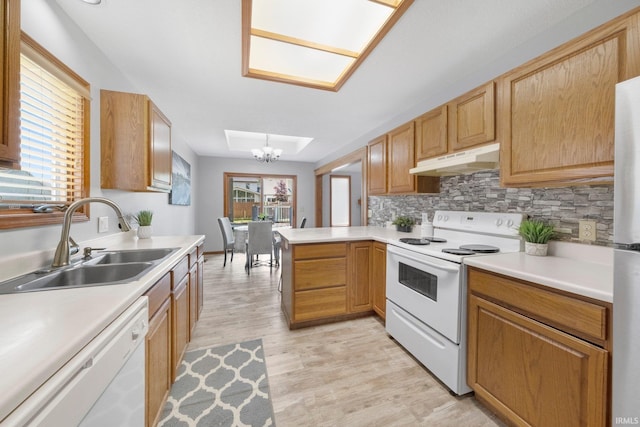 2319 Autumn Lake Pl, Fort Wayne, IN 46818 - kitchen featuring white appliances, under cabinet range hood, a chandelier, light wood finished floors, and a peninsula