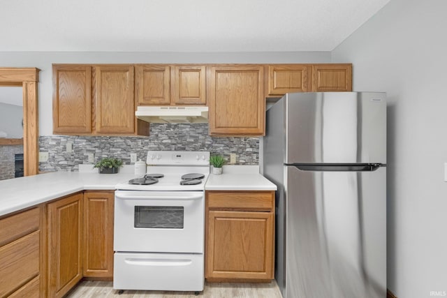 2319 Autumn Lake Pl, Fort Wayne, IN 46818 - kitchen featuring freestanding refrigerator, white electric stove, under cabinet range hood, decorative backsplash, and light countertops
