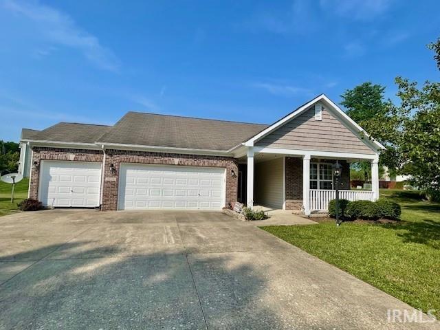 3239 S Parnel Ct, Bloomington, IN 47403 - view of front of house featuring brick siding, an attached garage, a front yard, and concrete driveway