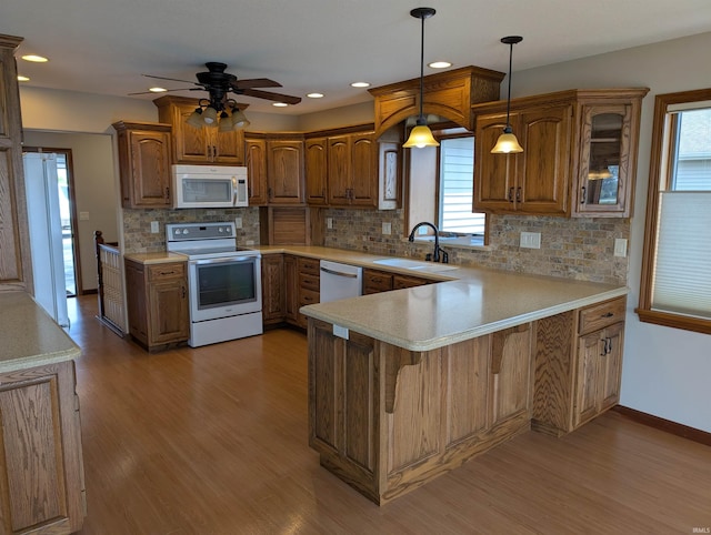 1260 Carrington Way, Berne, IN 46711 - kitchen with white appliances, a peninsula, light wood finished floors, plenty of natural light, and recessed lighting