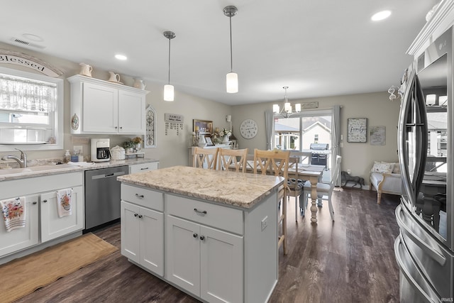 773 Sycamore St, Decatur, IN 46733 - kitchen featuring stainless steel appliances, white cabinetry, dark wood finished floors, a chandelier, and hanging light fixtures
