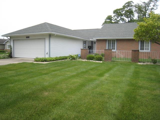 52289 Wembley Dr, South Bend, IN 46637 - ranch-style house featuring an attached garage, a front yard, driveway, brick siding, and a shingled roof