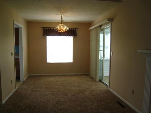 52289 Wembley Dr, South Bend, IN 46637 - empty room with healthy amount of natural light, a chandelier, and carpet floors
