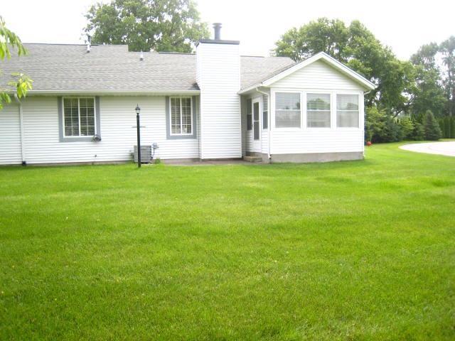 52289 Wembley Dr, South Bend, IN 46637 - back of house with a chimney and a lawn