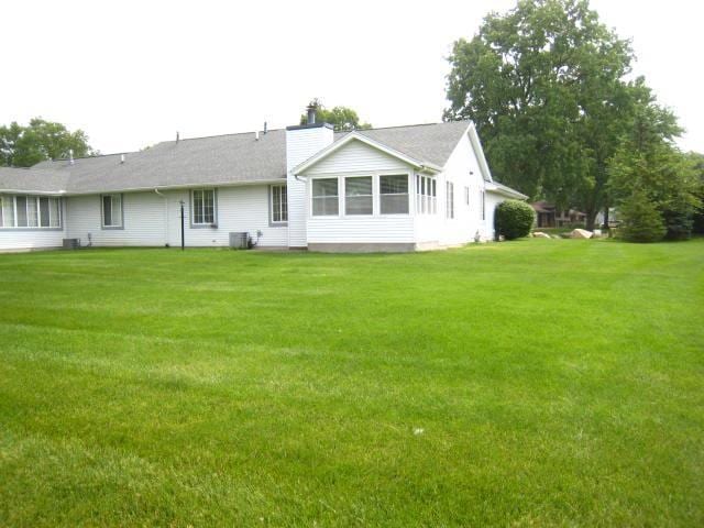 52289 Wembley Dr, South Bend, IN 46637 - rear view of house with a lawn and a chimney