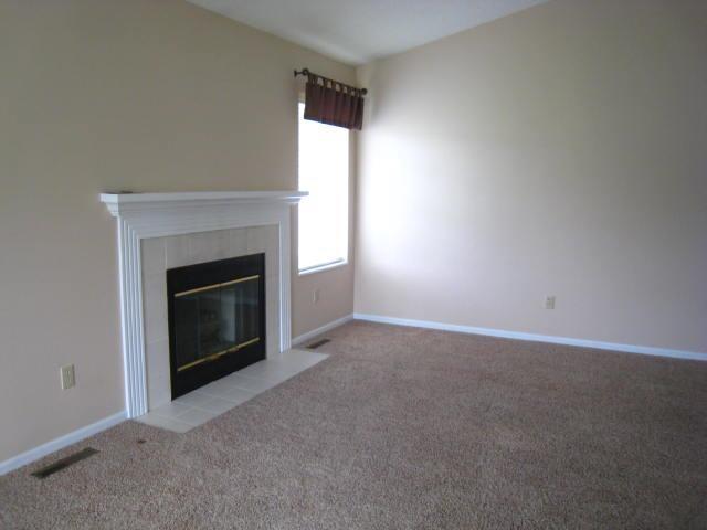 52289 Wembley Dr, South Bend, IN 46637 - unfurnished living room with carpet flooring and a fireplace