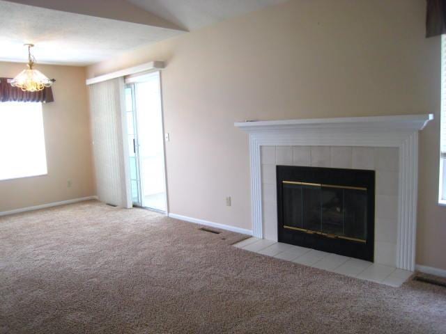 52289 Wembley Dr, South Bend, IN 46637 - unfurnished living room with carpet floors, a tiled fireplace, and a chandelier