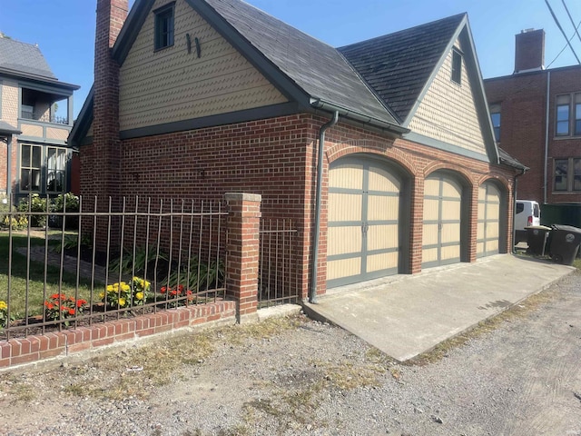 721 W Wayne St, Fort Wayne, IN 46802 - view of side of home featuring brick siding, a chimney, and an attached garage