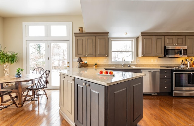921 S Sheridan Dr, Bloomington, IN 47401 - kitchen featuring stainless steel appliances, hardwood / wood-style floors, tasteful backsplash, and light stone counters