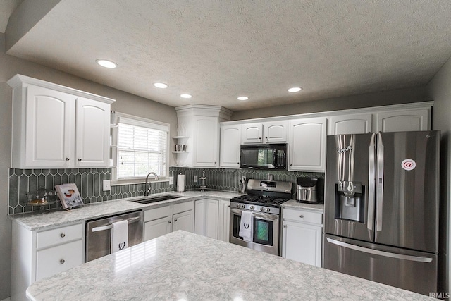2123 Bunker Ln, Evansville, IN 47725 - kitchen with stainless steel appliances, a textured ceiling, recessed lighting, white cabinets, and tasteful backsplash