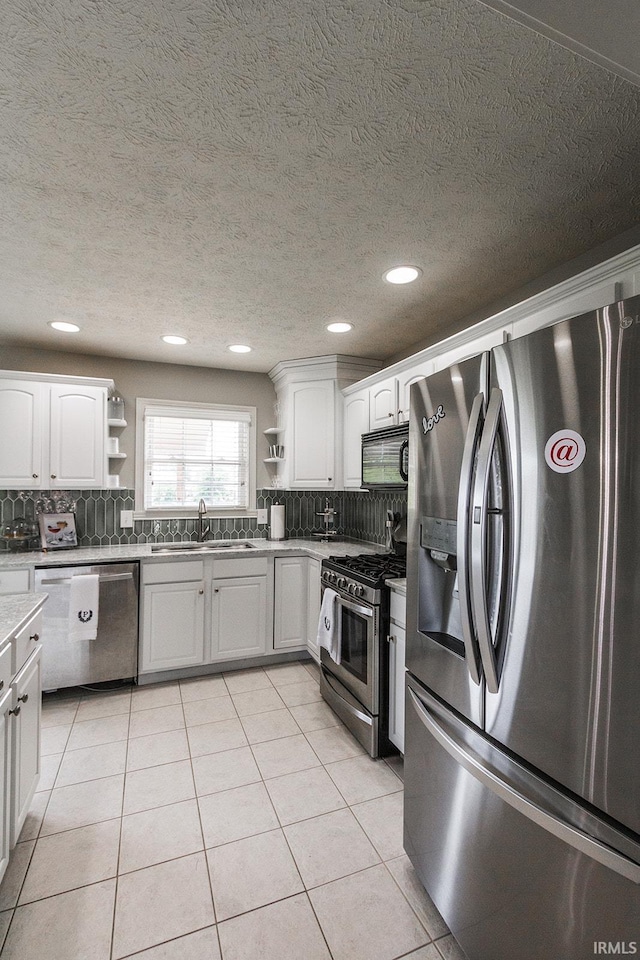 2123 Bunker Ln, Evansville, IN 47725 - kitchen featuring appliances with stainless steel finishes, open shelves, decorative backsplash, light tile patterned flooring, and white cabinetry