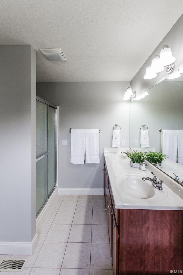 2123 Bunker Ln, Evansville, IN 47725 - bathroom with double vanity, a shower stall, tile patterned floors, and a textured ceiling