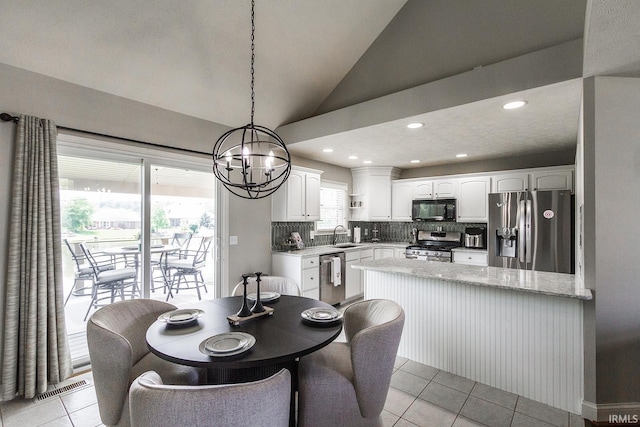 2123 Bunker Ln, Evansville, IN 47725 - dining area featuring a chandelier, light tile patterned flooring, vaulted ceiling, and recessed lighting