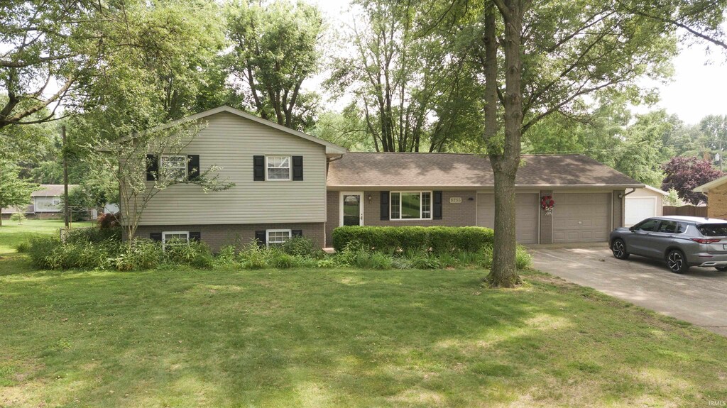 8255 Heather Dr, Newburgh, IN 47630 - tri-level home with a front lawn, an attached garage, driveway, and brick siding