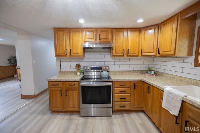 3529 S Walnut St, Muncie, IN 47304 - kitchen featuring stainless steel electric range, under cabinet range hood, light wood-style floors, brown cabinetry, and recessed lighting