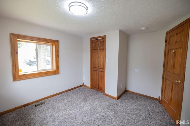 3529 S Walnut St, Muncie, IN 47304 - unfurnished bedroom featuring carpet, a textured ceiling, and a closet