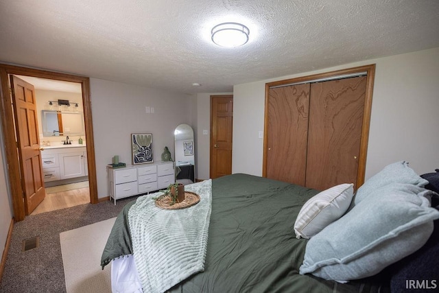 3529 S Walnut St, Muncie, IN 47304 - bedroom with a textured ceiling, a closet, light carpet, and connected bathroom