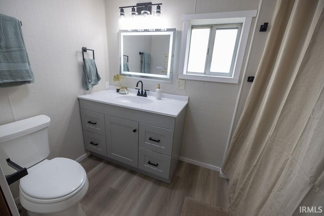3529 S Walnut St, Muncie, IN 47304 - bathroom with wood finished floors, vanity, tile walls, and a shower with shower curtain