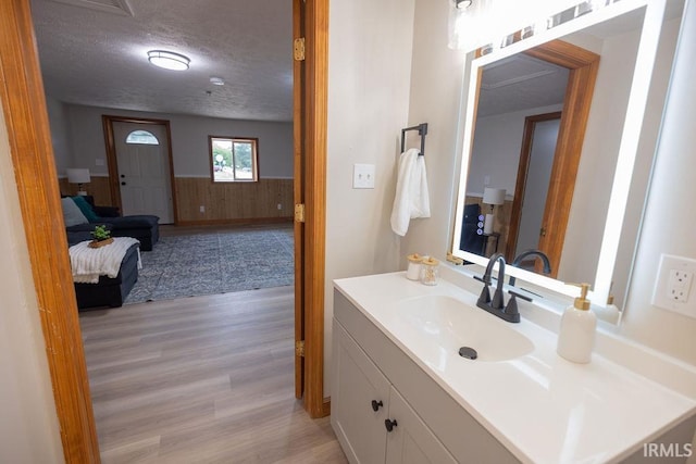 3529 S Walnut St, Muncie, IN 47304 - bathroom with wood finished floors, vanity, a wainscoted wall, wood walls, and a textured ceiling