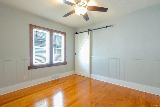 425 Gernhart Ave, Mishawaka, IN 46544 - spare room with light wood-style floors, wainscoting, a barn door, and ceiling fan
