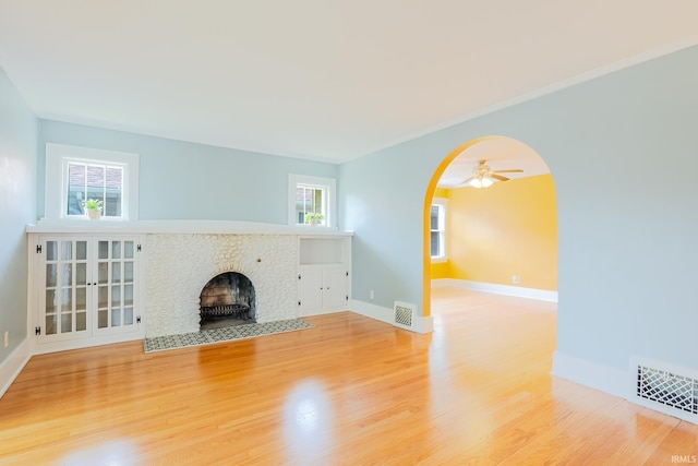 425 Gernhart Ave, Mishawaka, IN 46544 - unfurnished living room with arched walkways, wood finished floors, ceiling fan, and a fireplace