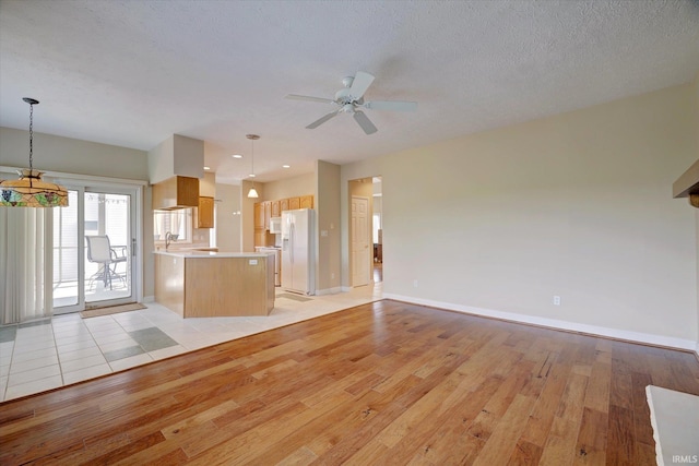 9109 S Front Nine Dr, Bloomington, IN 47401 - unfurnished living room featuring light wood finished floors, a ceiling fan, and a textured ceiling