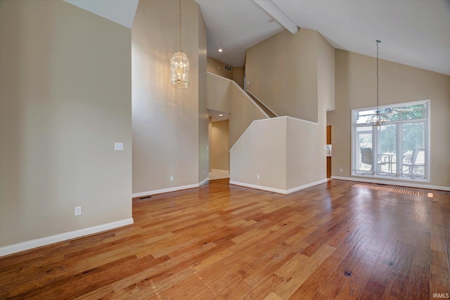 9109 S Front Nine Dr, Bloomington, IN 47401 - unfurnished living room with a chandelier, high vaulted ceiling, wood-type flooring, and beam ceiling