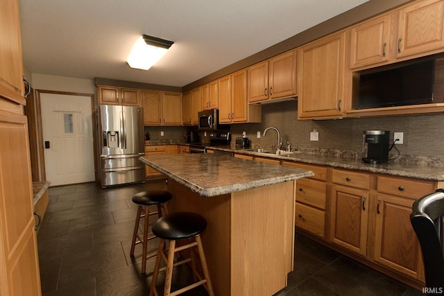 327 Hillside Ave, Roanoke, IN 46783 - kitchen featuring stainless steel appliances, a breakfast bar area, a kitchen island, backsplash, and dark countertops