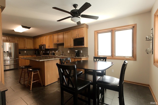 327 Hillside Ave, Roanoke, IN 46783 - kitchen featuring appliances with stainless steel finishes, dark tile patterned flooring, ceiling fan, dark countertops, and a center island