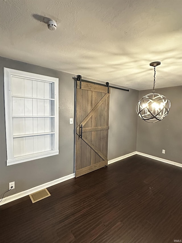 2023 E Columbia St, Evansville, IN 47711 - unfurnished room featuring dark wood-type flooring, a chandelier, a textured ceiling, a barn door, and a smoke detector
