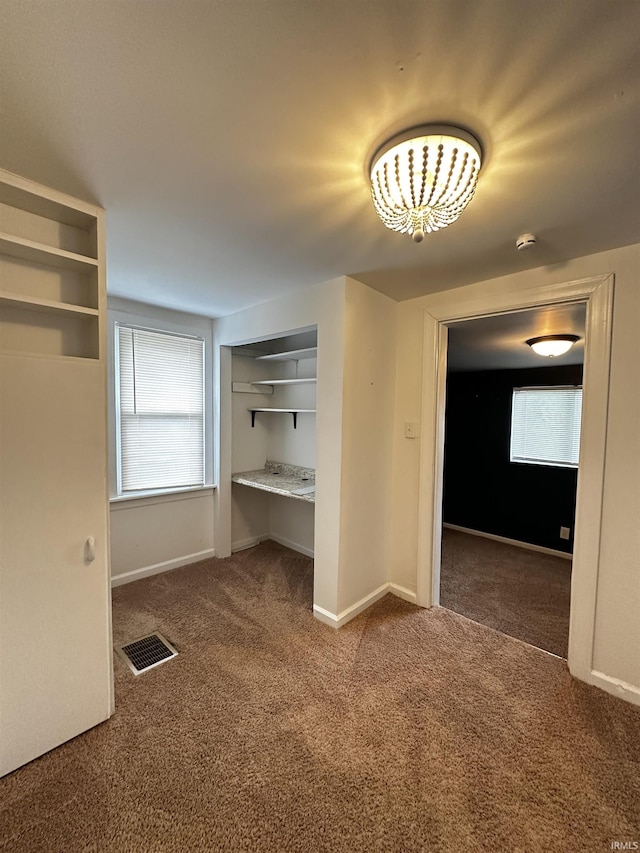 2023 E Columbia St, Evansville, IN 47711 - hallway featuring carpet flooring and a chandelier