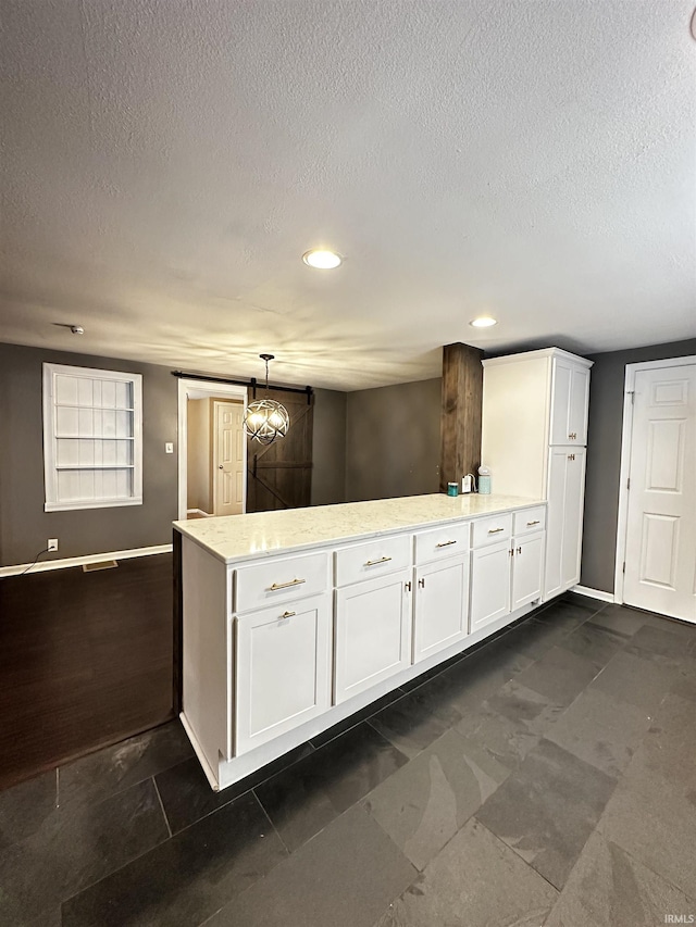 2023 E Columbia St, Evansville, IN 47711 - kitchen featuring a peninsula, white cabinets, a textured ceiling, recessed lighting, and hanging light fixtures