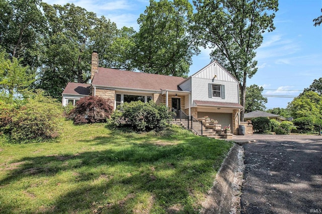 1730 Oak Park Dr, South Bend, IN 46617 - tri-level home featuring board and batten siding, asphalt driveway, a garage, stone siding, and a front lawn