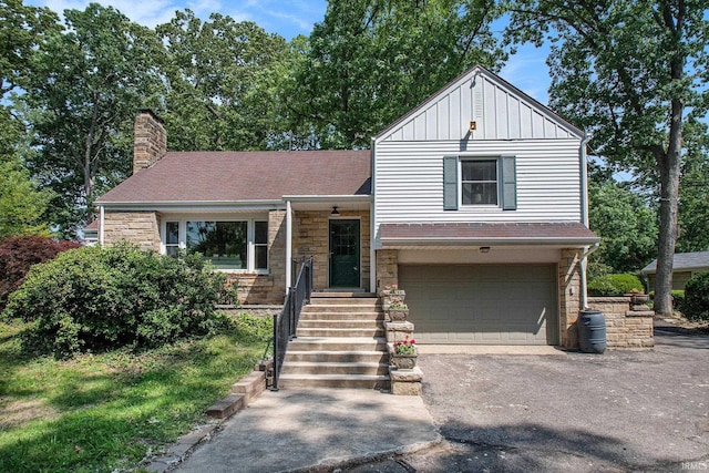 1730 Oak Park Dr, South Bend, IN 46617 - split level home featuring board and batten siding, driveway, a garage, and a chimney
