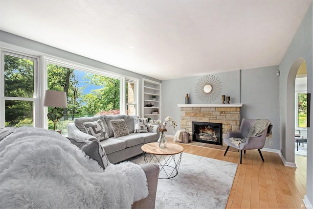 1730 Oak Park Dr, South Bend, IN 46617 - living area featuring arched walkways, a fireplace, light wood-type flooring, and built in shelves