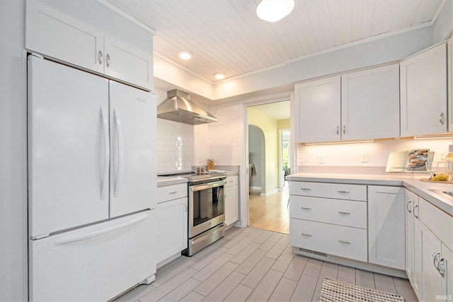 1730 Oak Park Dr, South Bend, IN 46617 - kitchen featuring freestanding refrigerator, stainless steel range with electric cooktop, ventilation hood, light countertops, and white cabinets
