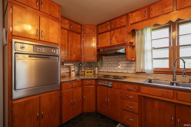 7420 S Fairfax Rd, Bloomington, IN 47401 - kitchen with stainless steel oven, under cabinet range hood, decorative backsplash, stovetop, and brown cabinetry