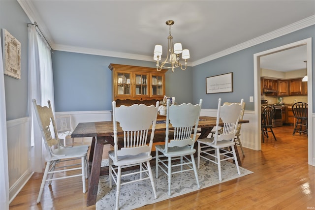 8855 Hickory Ln, Newburgh, IN 47630 - dining room featuring a chandelier, a wainscoted wall, ornamental molding, and light wood-style floors