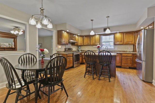 8855 Hickory Ln, Newburgh, IN 47630 - kitchen with appliances with stainless steel finishes, brown cabinetry, under cabinet range hood, and light wood finished floors