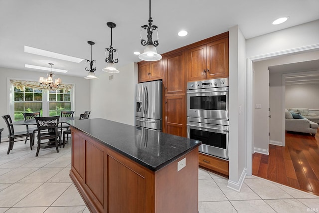 3726 Capilano Dr, West Lafayette, IN 47906 - kitchen featuring stainless steel appliances, a kitchen island, light tile patterned flooring, brown cabinets, and recessed lighting