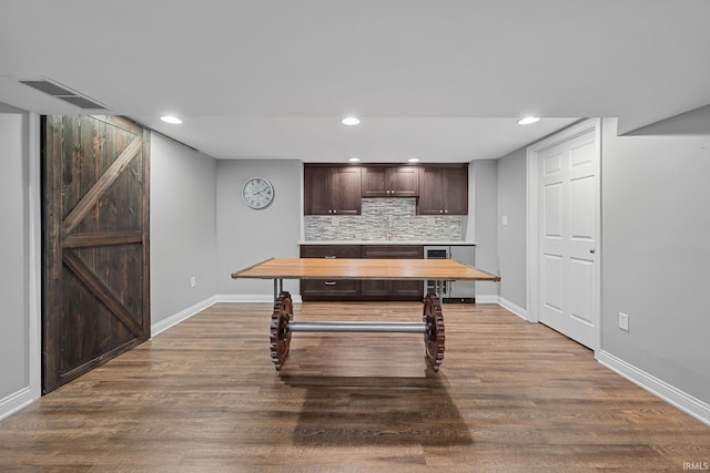 3726 Capilano Dr, West Lafayette, IN 47906 - kitchen with dark brown cabinetry, backsplash, wood finished floors, light countertops, and recessed lighting