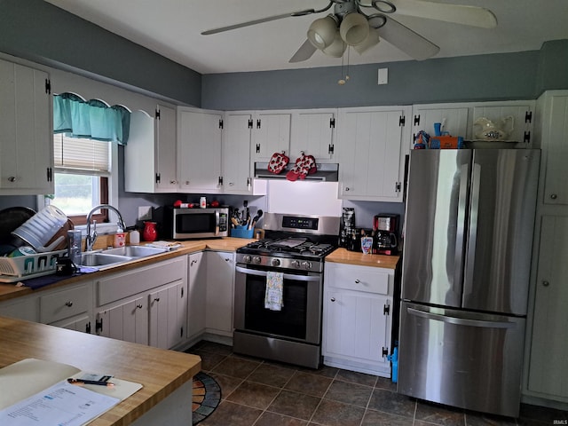 622 S Market St, Winamac, IN 46996 - kitchen with appliances with stainless steel finishes, a ceiling fan, white cabinets, and range hood