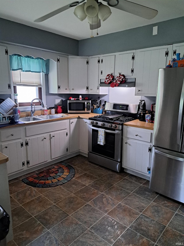 622 S Market St, Winamac, IN 46996 - kitchen with stainless steel appliances, ceiling fan, white cabinets, ventilation hood, and dark stone finish flooring